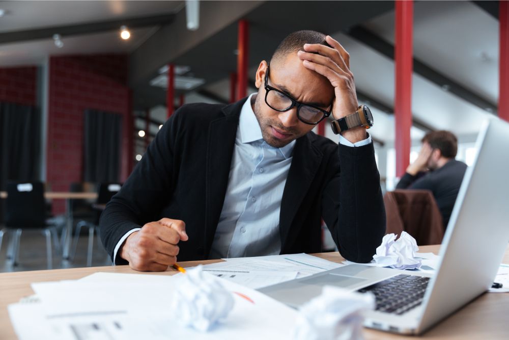 Remote interview questions: what do you do when you are unsure how to approach a task? A confused man looking at his computer.