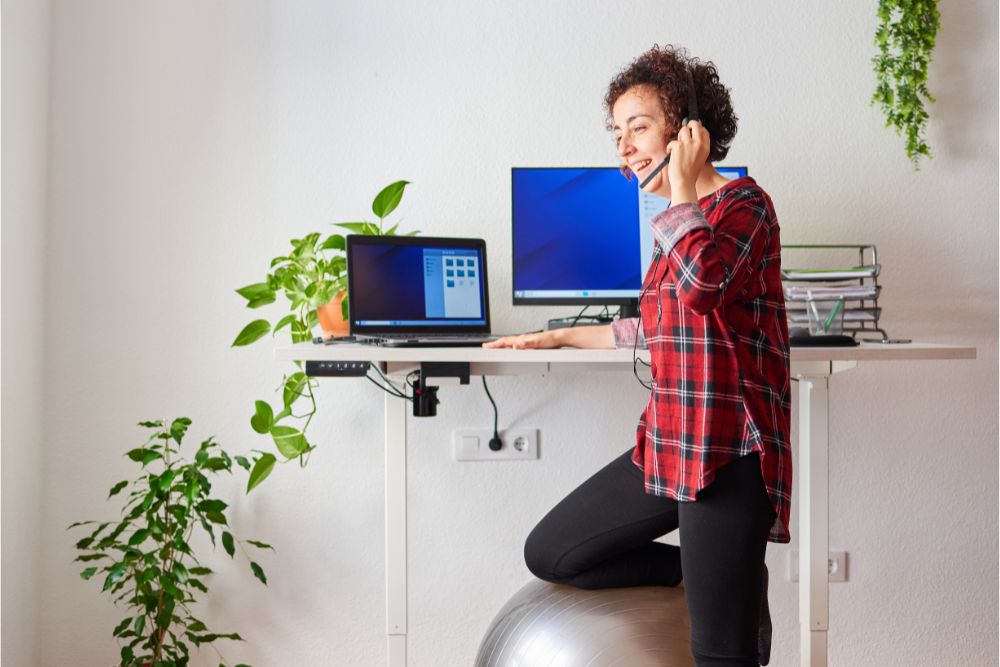 Woman using a standing desk to stay active while working from home.