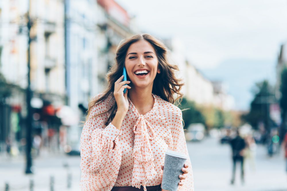 A woman walking while taking a phone call to stay active while working from home.
