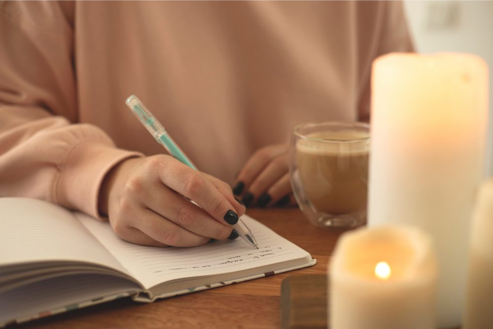 A woman journaling to self-reflect and enhance her emotional intelligence.